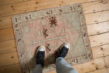 Distressed vintage Oushak rug featuring a tree of life motif in dusty blush and chestnut hues.