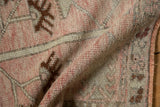 Distressed Oushak rug pile showing dusty blush, beige, silver tones, and side selvage.