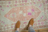 Distressed Oushak rug's low-pile texture and scale, with mauve, slate blue, and raspberry accents.