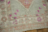Worn hand-knotted texture and floral border in raspberry and mauve on a vintage Oushak rug.