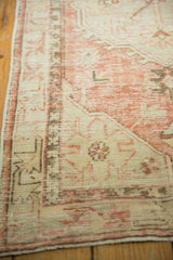 Distressed Oushak runner showing worn geometric patterns, rose, ivory, and exposed foundation.