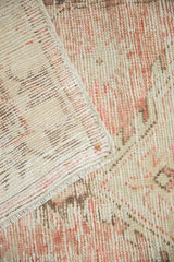 Visible foundation and worn pile on distressed Oushak runner in dusty rose and antique ivory.