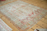 Close-up of the distressed geometric blossom main border and worn field of the Oushak rug.