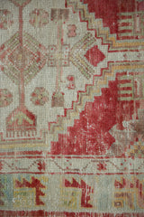 Detail of the distressed Oushak rug showing areas of pile worn to the knot heads.