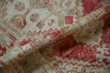 Folded view revealing the distressed texture and hand-knotted pile of a vintage Turkish Oushak rug.