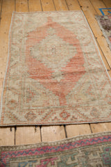 Angled perspective of a distressed Turkish Oushak rug with a worn, low-pile texture.