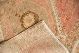 Distressed Kars rug runner: worn dusty blush pile, faint foundation, and secured selvage.