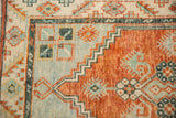 Worn knot heads on the stepped corner design of a vintage Oushak runner in rust and teal.