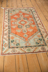 Perspective view of a distressed Turkish Oushak runner in rust, ivory, and charcoal teal.