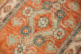The worn, low-pile texture of a vintage Oushak rug with rust and mint floral blossoms.