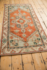 Angled perspective of a vintage Oushak runner highlighting its distressed texture and rust medallion.