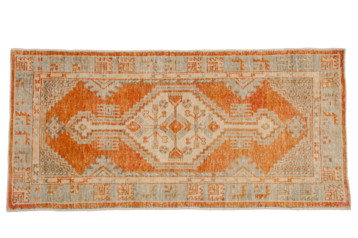 Vintage distressed Oushak rug runner with a hexagonal medallion in pale rust, powder blue, and ivory.