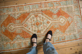Overhead view showing the scale and soft colors of a distressed Oushak runner.