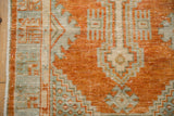 Distressed vintage Oushak rug runner's geometric border in pale rust and powder blue.
