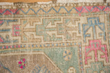 Geometric border and corner spandrel details in dusty mint green, fuchsia, and ivory tones.