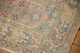 Primitive geometric border in mint green and mauve on a distressed vintage Oushak rug corner.