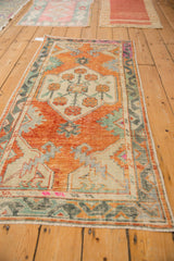 Abrashed corner of a vintage Oushak runner, highlighting primitive arabesque border in seafoam and rust.