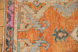 Textured pile of a vintage Oushak runner's border in rust, magenta, and seafoam green.