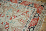 Repeating charcoal starburst and red serrated borders on a distressed vintage Anatolian rug.