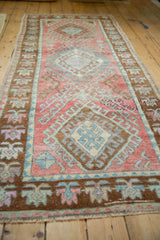 Blush and mint medallion with hook-latch design, showing even wear on vintage Oushak rug.