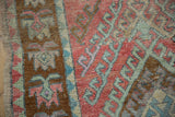 Vintage distressed Oushak runner with geometric hook and latch pattern in blush, mint green, bronze.