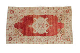 Distressed Anatolian rug with a scrolling medallion on an abrashed pomegranate red field and ivory spandrels.