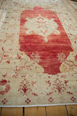 Low-angle view of a vintage Turkish rug showing its distressed texture and abrashed pomegranate red field.