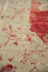 Close-up of the distressed pile showing even wear to knot heads on the rug's ivory and red border.