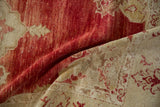 A folded corner on a distressed Turkish rug reveals the evenly worn, hand-knotted pile in red and ivory.