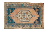 Vintage distressed Turkish Oushak rug with a geometric medallion on an abrashed sandalwood and teal field.