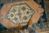 Evenly worn pile on a distressed Oushak rug featuring a primitive floral medallion.
