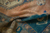 The soft, worn texture of a vintage distressed Oushak rug in sandalwood and deep teal.