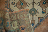 Soft, even-worn pile and hand-knotted back of a distressed Oushak rug at the corner.