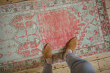 The soft, lived-in texture and faded palette of a vintage distressed Oushak rug runner.
