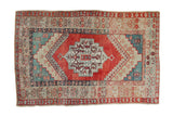 Vintage distressed Anatolian rug with a single stepped medallion in abrashed shades of ruby red and teal.