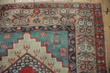 Corner detail of a vintage Anatolian rug showing the stepped medallion, abrashed teal field, and floral borders.