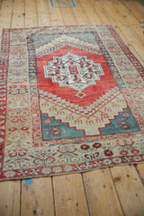 The colorful geometric design of a distressed Anatolian rug, viewed from a high-angle perspective.