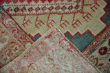 A folded corner reveals the hand-knotted back and trident motifs of a distressed Anatolian rug.