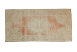 Distressed vintage Turkish Oushak runner with a faded medallion in soft dusty rose and ivory.