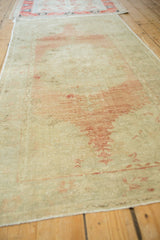 Angled view showing the soft patina and abrashed texture of a vintage Oushak runner.