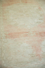 Distressed vintage Oushak rug texture showing even wear, white knots, and a faded blush patina.