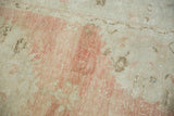 Heavily abrashed texture of the distressed rug's low pile with visible white knots.
