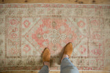 Distressed Oushak runner with dusty blush quatrefoil pattern, exhibiting mostly even wear.