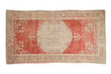 Vintage distressed Oushak rug in cherry red and ivory with a large central medallion and floral spandrels.