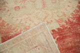 Folded corner of a vintage Oushak rug revealing the hand-knotted weave and distressed low pile.
