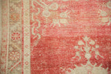 Close-up of the vintage Oushak's wear, with cherry red pile low to the knot heads.