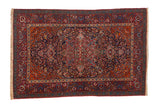 Antique fine Kashan rug with a complex central medallion on a navy field and ruby red floral borders.