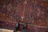 Elaborate cloudband and palmette details on an antique Kashan rug in vivid, gem-like colors.
