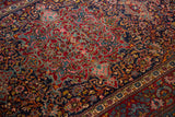 Intricate scrolling vines and cloudband motifs in gem-tones on a fine antique Kashan rug.