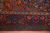 Elaborate palmette and scrolling vine border on a ruby red ground of a fine antique Kashan rug.